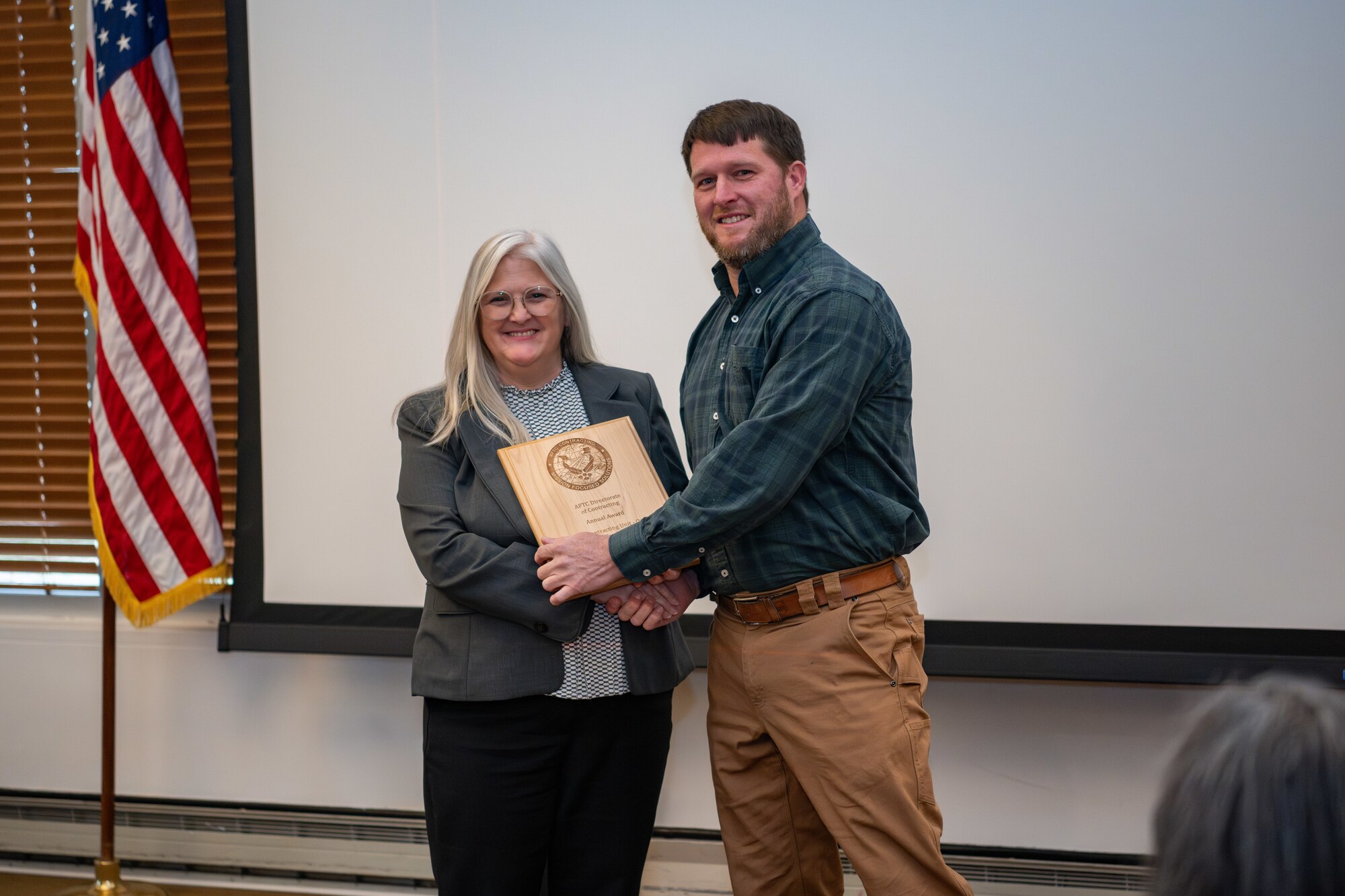 Arnold Engineering Development Complex Test Range Contracting Division Chief Rebecca Gardner presents AEDC Installation Contracting Division Chief Christopher Fanning with a plaque recognizing the Installation Contracting Division as the 2024 fiscal year winner of the Air Force Test Center award for Outstanding Operational Contracting Unit (Small) during the AEDC Annual Awards ceremony Feb. 13, 2025, at Arnold Air Force Base, Tenn. (U.S. Air Force photo by Keith Thornburgh)