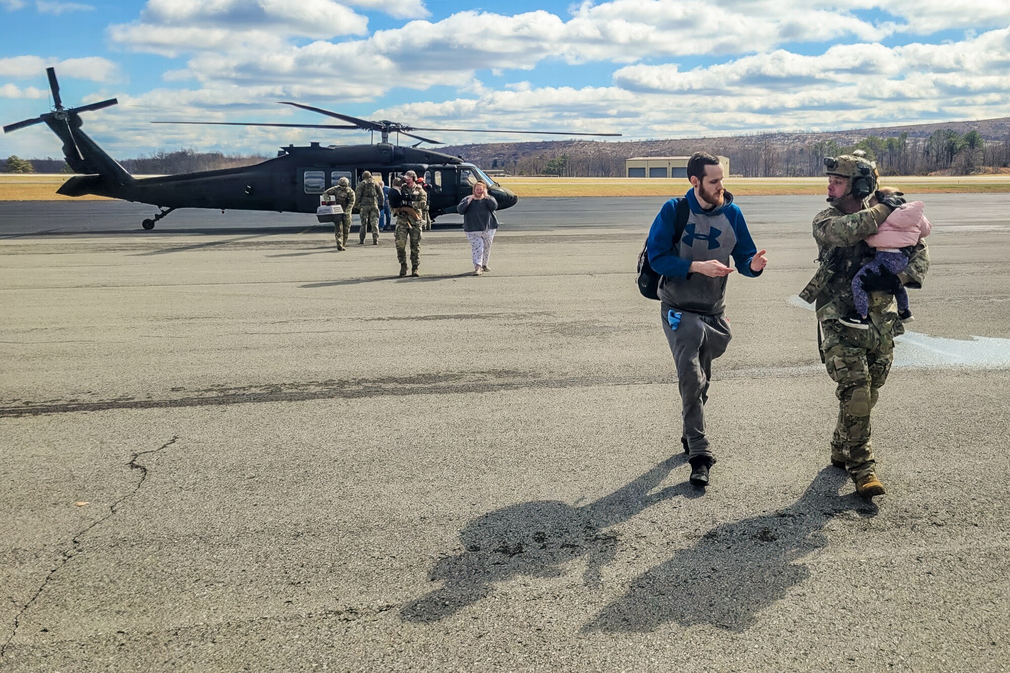Airmen from the Kentucky Air National Guard’s 123rd Contingency Response Group receive flood victims arriving at the Big Sandy Regional Airport in Debord, Kentucky, Feb. 17, 2025. The evacuees were airlifted aboard Kentucky and Indiana Army National Guard helicopters from housing complexes in Martin County, Kentucky, that were surrounded by floodwaters. (U.S. Air National Guard photo by Master Sgt. Kyle Goins)
