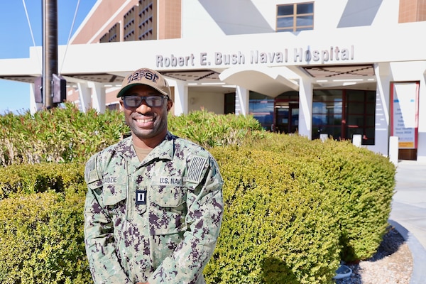 Lt. Emmanuel Dadzie, Chief Informatics Officer at Navy Medicine Readiness and Training Command (NMRTC) Twentynine Palms, stands in front of Naval Hospital Twentynine Palms on Feb. 14, 2024 after being named Navy Medicine’s 2024 Junior Health Information Technology Officer of the Year. Recognized for his leadership and innovation, Dadzie played a pivotal role in modernizing the command’s IT infrastructure and integrating the Military Health System (MHS) Genesis electronic health record into field operations, enhancing medical support for operational forces aboard Marine Corps Air Ground Combat Center Twentynine Palms. His efforts have streamlined healthcare accessibility in austere environments, ensuring providers can access critical patient data in real time (U.S. Navy photo by Christopher C. Jones, NHTP/NMRTC Twentynine Palms public affairs officer).