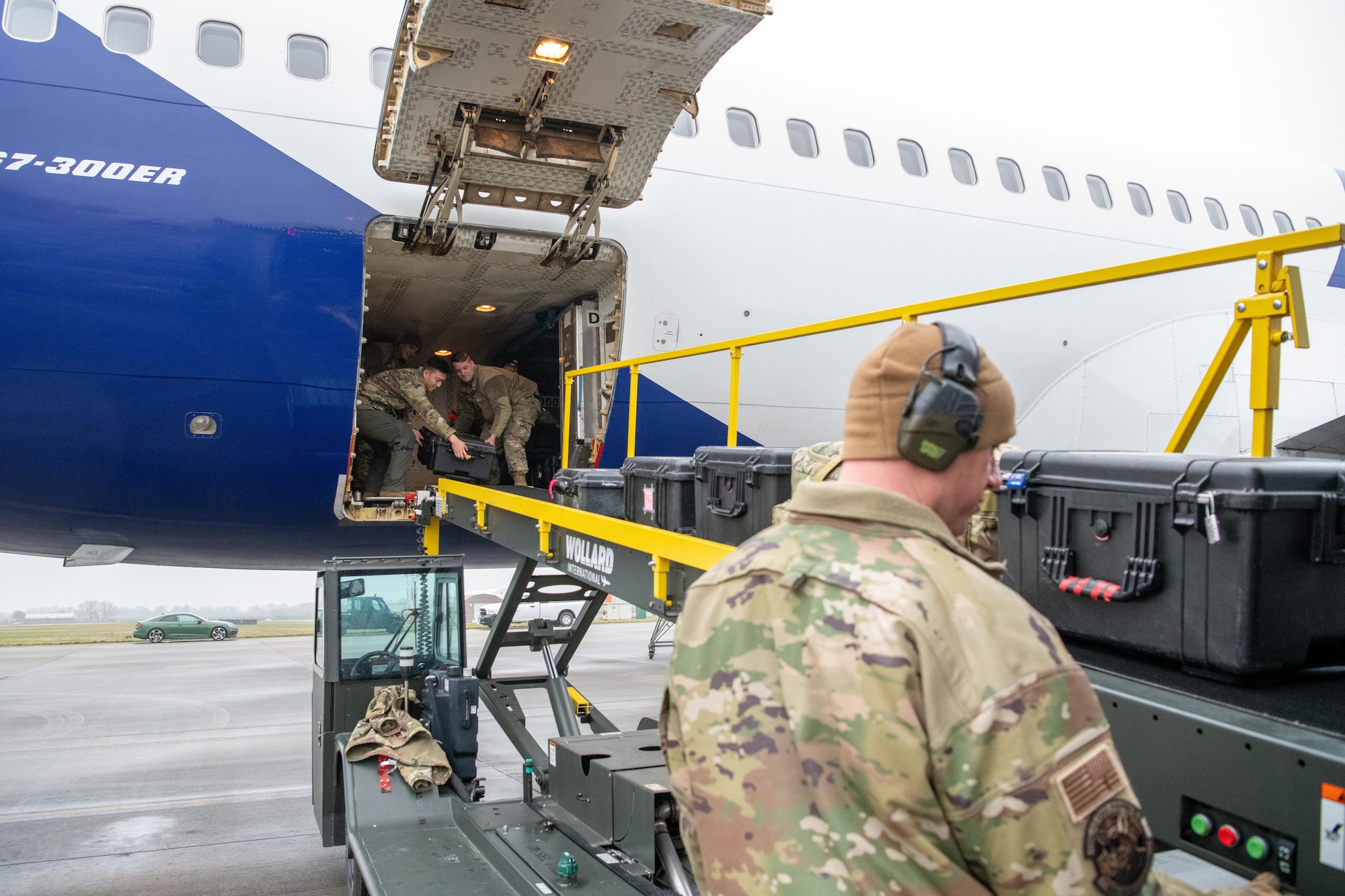 Airmen offload luggage aboard an Atlas Air Boeing 767 aircraft