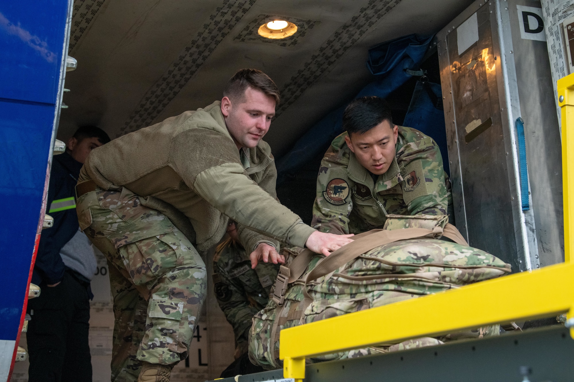 Airmen offload luggage aboard an Atlas Air Boeing 767 aircraft