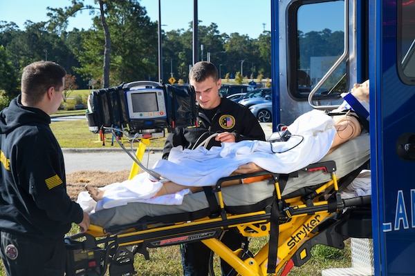 Lt. Junior Grade Andrew Mappus, critical care nurse, right, and Jesiah Hostetler, critical care paramedic, unload a simulated casualty from an ambulance during a trauma drill at Naval Medical Center Camp Lejeune on October 18, 2024. The drill reviews processes and procedures in place for trauma care.