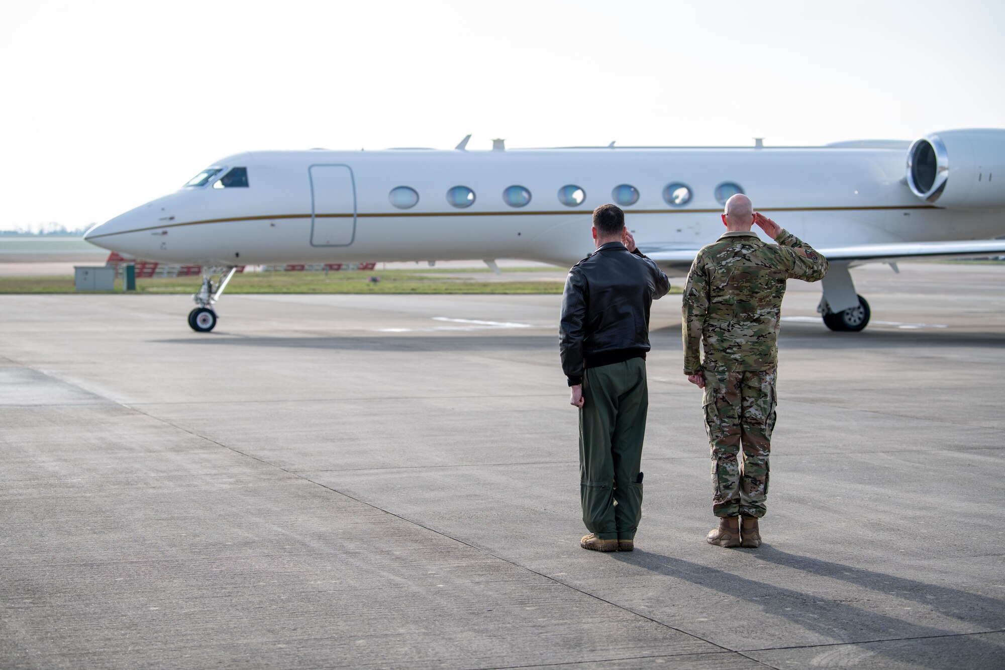 Leaders salute a Gulfstream C-37A as it departs