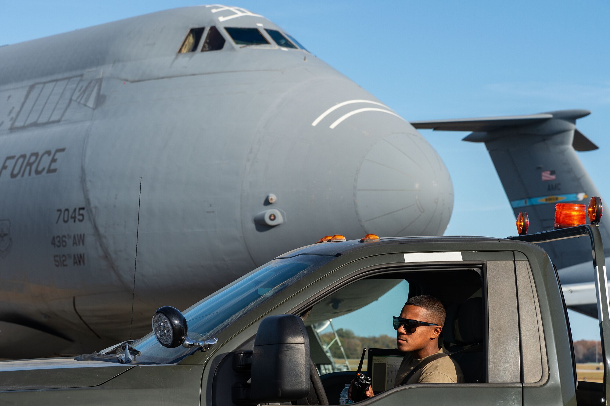 U.S. Air Force Senior Airman Ricardo Santos, 436th Maintenance Squadron aerospace ground equipment journeyman, stops in front of a parked C-5M Super Galaxy at Dover Air Force Base, Delaware, Nov. 6, 2024. The AGE flight is one of five flights within the 436th MXS that inspects, maintains, services and repairs AGE to support C-5M Super Galaxy, C-17 Globemaster III and Transient Alert maintenance activities. (U.S. Air Force photo by Roland Balik)