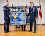 Airmen from the 123rd Medical Group present Col. Hans Otto, right, outgoing group commander, with a framed unit flag during his retirement ceremony at the Kentucky Air National Guard Base in Louisville, Ky., Dec. 15, 2024. Otto’s career spanned 27 years across multiple assignments in the active-duty Air Force, Air Force Reserve and Air National Guard. (U.S. Air National Guard photo by Tech. Sgt. Chloe Ochs)