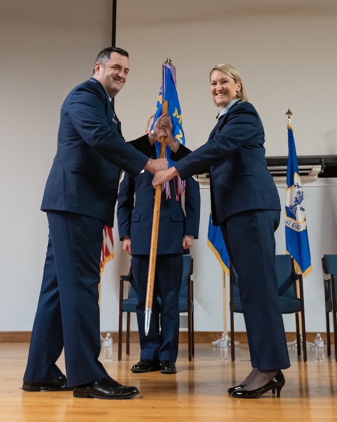 Col. Patricia Adams, right, assumes command of the 123rd Medical Group as she accepts the unit guidon from Col. Matthew Quenichet, commander of the 123rd Airlift Wing, during a change-of-command ceremony at the Kentucky Air National Guard Base in Louisville, Ky., Dec. 15, 2024.