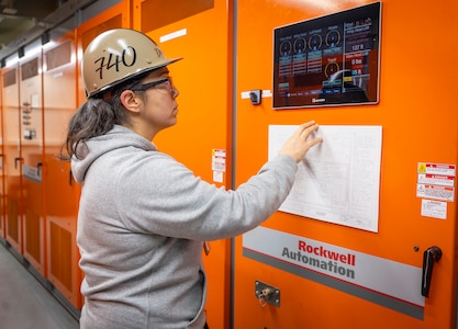 Rebecca DeRusha, portal crane supervisor, Code 740, Riggers, checks the Human-Machine Interface located inside Crane 62's machinery house. The new HMI system helps monitor various crane functions, including boom radius and helps track trends for crane maintenance crews to troubleshoot. (U.S. Navy photo by Wendy Hallmark)