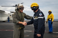 Adm. Steve Koehler, commander, U.S. Pacific Fleet, and Adm. Nicolas Vaujour, chief of staff of the French Navy, greet one another aboard the aircraft carrier FS Charles De Gaulle (R 91) in the Philippine Sea during Pacific Steller 2025, Feb. 14.