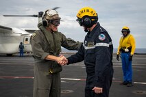 Adm. Steve Koehler, commander, U.S. Pacific Fleet, and Adm. Nicolas Vaujour, chief of staff of the French Navy, greet one another aboard the aircraft carrier FS Charles De Gaulle (R 91) in the Philippine Sea during Pacific Steller 2025, Feb. 14.