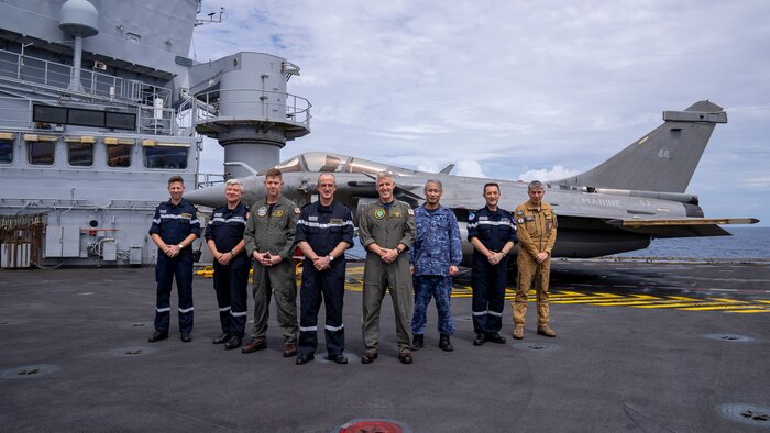 From left, Capt. Georges-Antoine Florentin, commanding officer of the aircraft carrier FS Charles De Gaulle (R 91); Adm. Guillaume Pinget, commander, Armed Forces of French Polynesia; U.S. Navy Rear Adm. Michael Wosje, commander, Carrier Strike Group (CSG) ONE; Adm. Nicolas Vaujour, chief of staff of the French Navy; Adm. Steve Koehler, commander, U.S. Pacific Fleet; Rear Adm. Natsui Takashi, commander, Japan-Maritime Self-Defense Force Escort Flotilla Four; Rear Adm. Jacques Mallard, commander, French Carrier Strike Group; and Cmdr. Guillaume Denis, commander, French Carrier Air Wing, join together on the flight deck of Charles De Gaulle in the Philippine Sea during Pacific Steller 2025, Feb. 14.