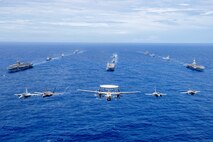 Aircraft from the Carl Vinson Carrier Strike Group (VINCSG) and French Carrier Strike Group (CSG) fly in formation over the Philippine Sea with ships from VINCSG, French CSG, the Japan Maritime Self-Defense Force (JMSDF), and U.S. Military Sealift Command (MSC) during Pacific Steller 2025.