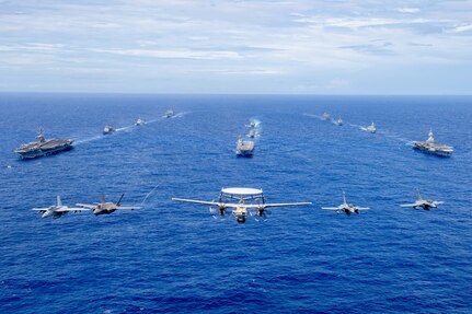 Aircraft from the Carl Vinson Carrier Strike Group (VINCSG) and French Carrier Strike Group (CSG) fly in formation over the Philippine Sea with ships from VINCSG, French CSG, the Japan Maritime Self-Defense Force (JMSDF), and U.S. Military Sealift Command (MSC) during Pacific Steller 2025.
