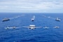Aircraft from the Carl Vinson Carrier Strike Group (VINCSG) and French Carrier Strike Group (CSG) fly in formation over the Philippine Sea with ships from VINCSG, French CSG, the Japan Maritime Self-Defense Force (JMSDF), and U.S. Military Sealift Command (MSC) during Pacific Steller 2025.