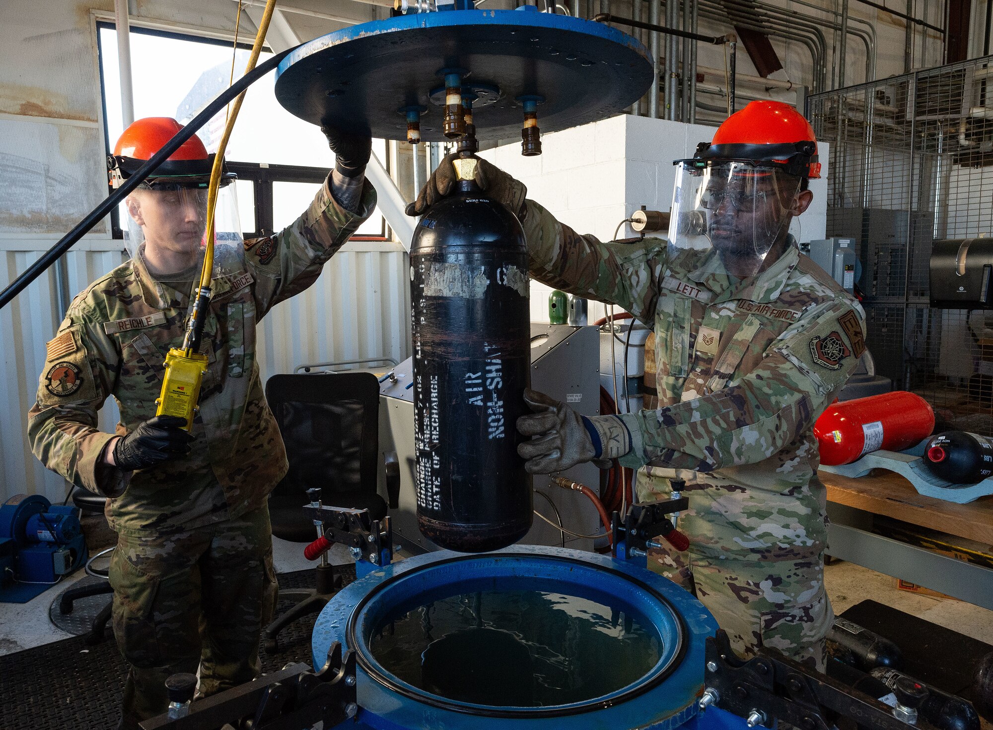 U.S. Air Force Senior Airman Carter Reichle, left, 436th Maintenance Squadron electrical and environmental systems journeyman, and Staff Sgt. Michael Lett, right, 436th MXS electrical and environmental systems apprentice, move an aircraft slide bottle into position for a hydrostatic check at Dover Air Force Base, Delaware, Nov. 6, 2024. The electro-environmental section is part of the accessories flight within the 436th MXS that performs the inspection and repair of C-5M Super Galaxy and C-17 electro-environmental systems and components. (U.S. Air Force photo by Roland Balik)
