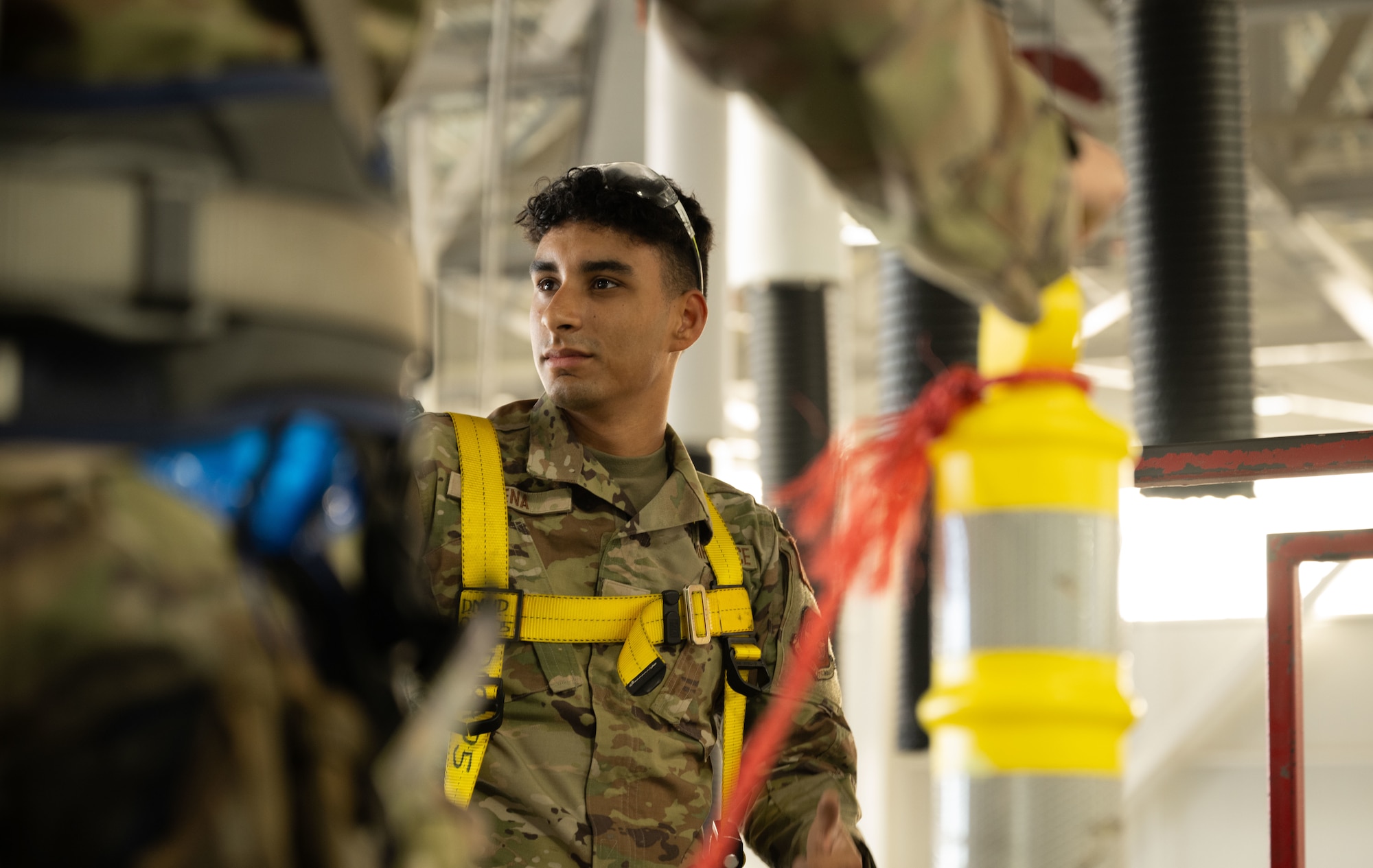 U.S. Airman 1st Class Jayden Pena, 436th Maintenance Squadron aerospace maintenance technician, looks to his peers on top of the C-5M Super Galaxy at Dover Air Force Base, Delaware, Oct. 21, 2024. The 436th MXS Isochronal Inspection Dock is the primary inspection sector for the C-5. (U.S. Air Force photo by Airman 1st Class Liberty Matthews)