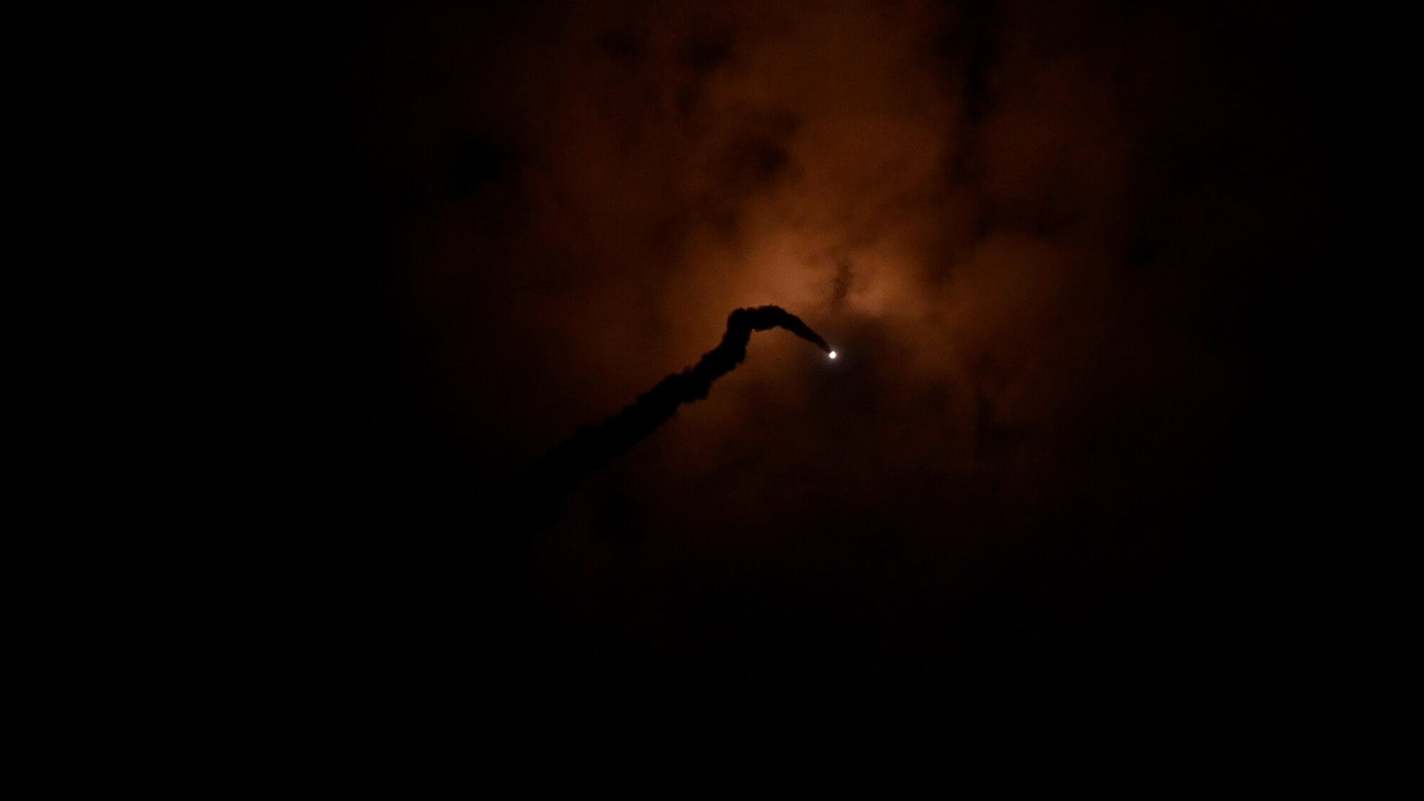 A missile fires through clouds