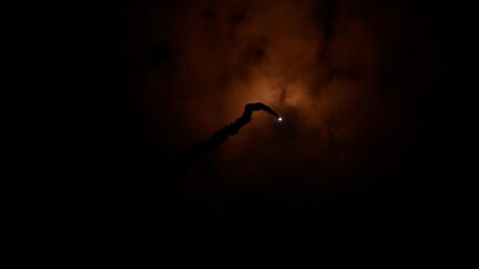 A missile fires through clouds