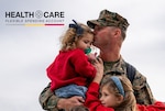Man embracing two children.
