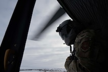 U.S. Air Force Staff Sgt. Garrett Hightower, 54th Helicopter Squadron flight engineer, looks out of a UH-1N Iroquois during a flight at Minot Air Force Base, North Dakota, Feb. 7, 2025. Based on the phonetic sound of its initial designation, HU-1, the UH-1 is referred to as a "Huey." (U.S. Air Force photo by Senior Airman Alyssa Bankston)
