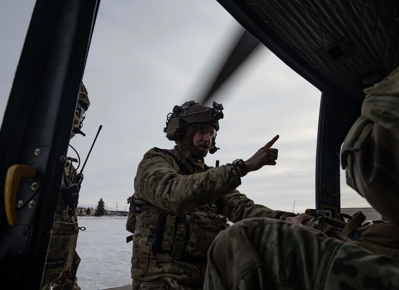 U.S. Air Force Staff Sgt. Robert Taulman, 91st Missile Security Operations Squadron convoy response force fire observer, enters a UH-1N Iroquois assigned to the 54th Helicopter Squadron (54HS) at Minot Air Force Base, North Dakota, Feb. 7, 2025. In addition to providing helicopter security response for the 91st Missile Wing, the 54HS supports emergency war orders by delivering tactical response force teams to assist with convoy operations, launch facility denial and recapture. (U.S. Air Force photo by Senior Airman Alyssa Bankston)