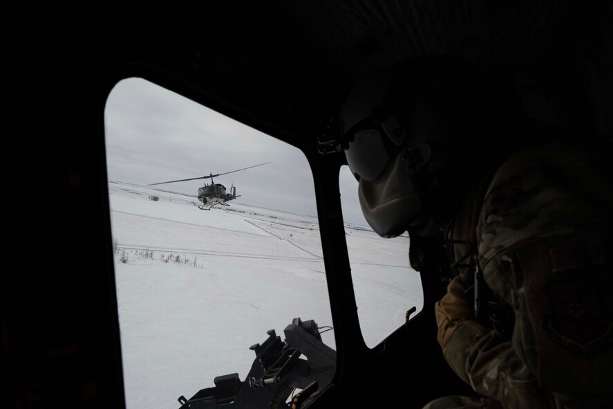 U.S. Air Force Staff Sgt. Garrett Hightower, 54th Helicopter Squadron flight engineer, looks out of a UH-1N Iroquois during flight at Minot Air Force Base, North Dakota, Feb. 7, 2025. Since the 1950s, the UH-1 “Huey” has been used by the Department of Defense with widespread use during the Vietnam War. (U.S. Air Force photo by Senior Airman Alyssa Bankston)