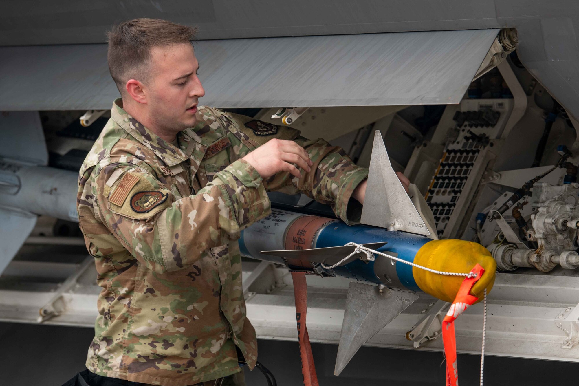 U.S. Air Force Staff Sgt. Ian Crider, 525th Fighter Generation Squadron weapon load crew member, secures munitions onto an F-22A Raptor during a weapons load competition at Kadena Air Base, Japan, Feb. 7, 2025.