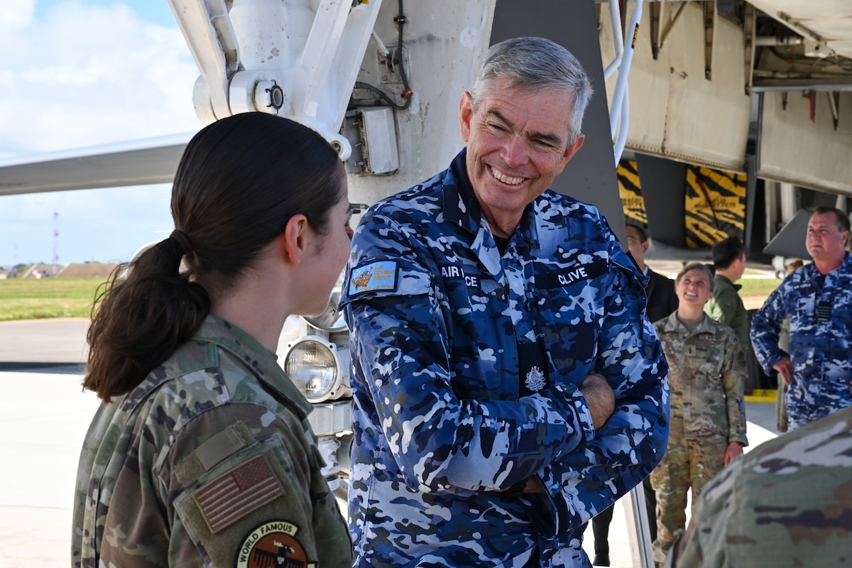 Royal Australian Air Force Warrant Officer Gregory Clive, from RAAF Air Combat Group, speaks with Senior Airman Tia Cook, 34th Expeditionary Bomb Squadron B-1 avionics technician, during a Cope North 2025 distinguished visitors tour of a B-1B Lancer at Andersen Air Force Base, Guam, Feb. 12, 2025.