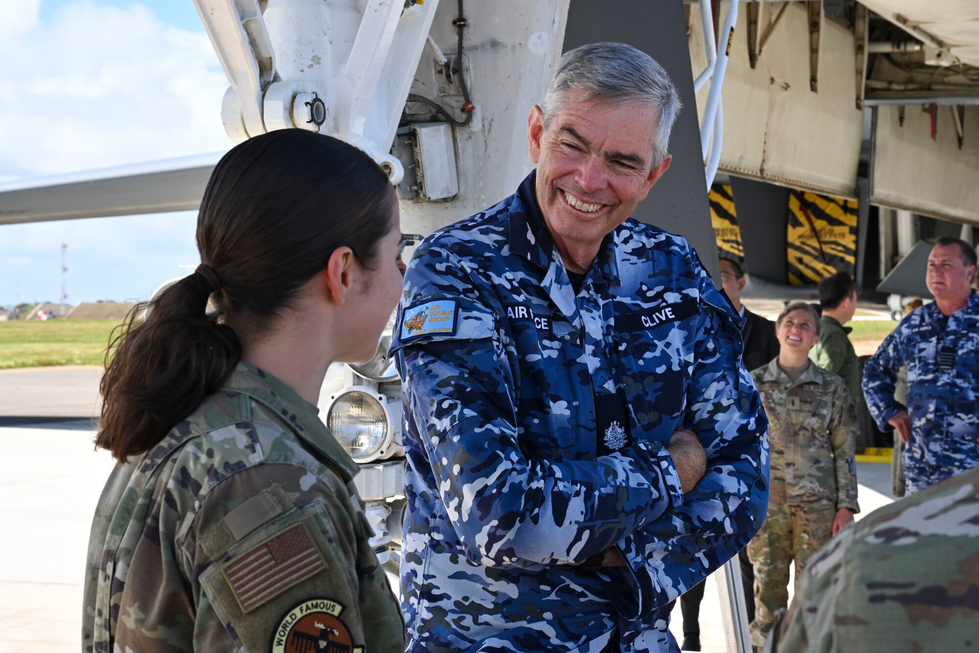 Royal Australian Air Force Warrant Officer Gregory Clive, from RAAF Air Combat Group, speaks with Senior Airman Tia Cook, 34th Expeditionary Bomb Squadron B-1 avionics technician, during a Cope North 2025 distinguished visitors tour of a B-1B Lancer at Andersen Air Force Base, Guam, Feb. 12, 2025.