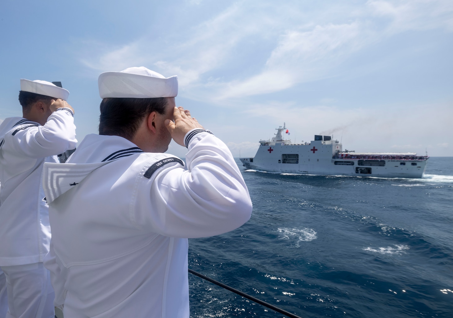 Sailors aboard the Arleigh Burke-class guided-missile destroyer USS Dewey (DDG 105) render honors to the Sudirohusodo-class hospital ship KRI dr. Radjiman Wedyodiningrat (992) during Multinational Exercise Komodo (MNEK) 2025, in the Bali Sea, Feb. 16, 2025.