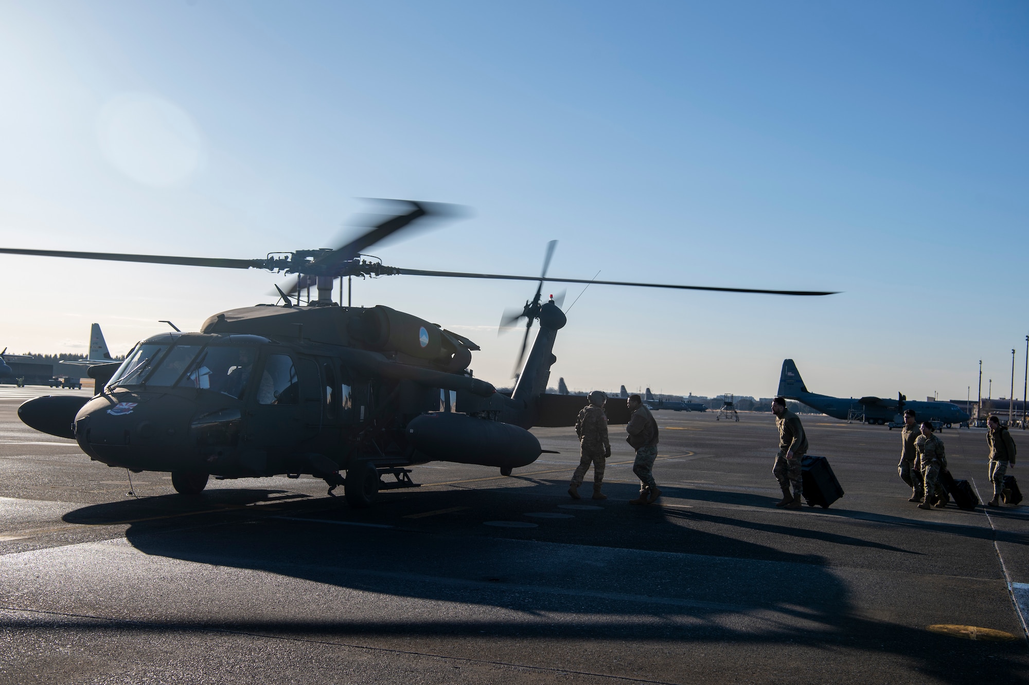 Airmen board a U.S. Army UH-60 Blackhawk assigned to the 52nd Aviation Regiment.