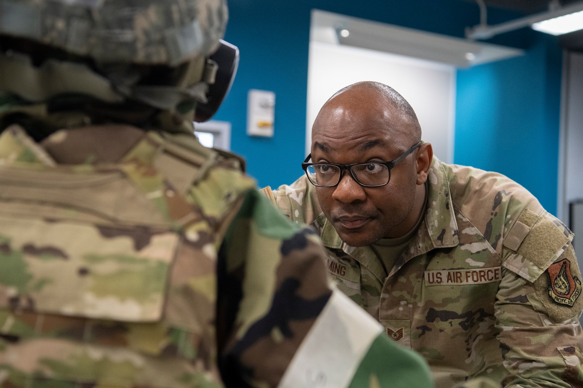 An airman inspects mission-oriented protective posture gear.