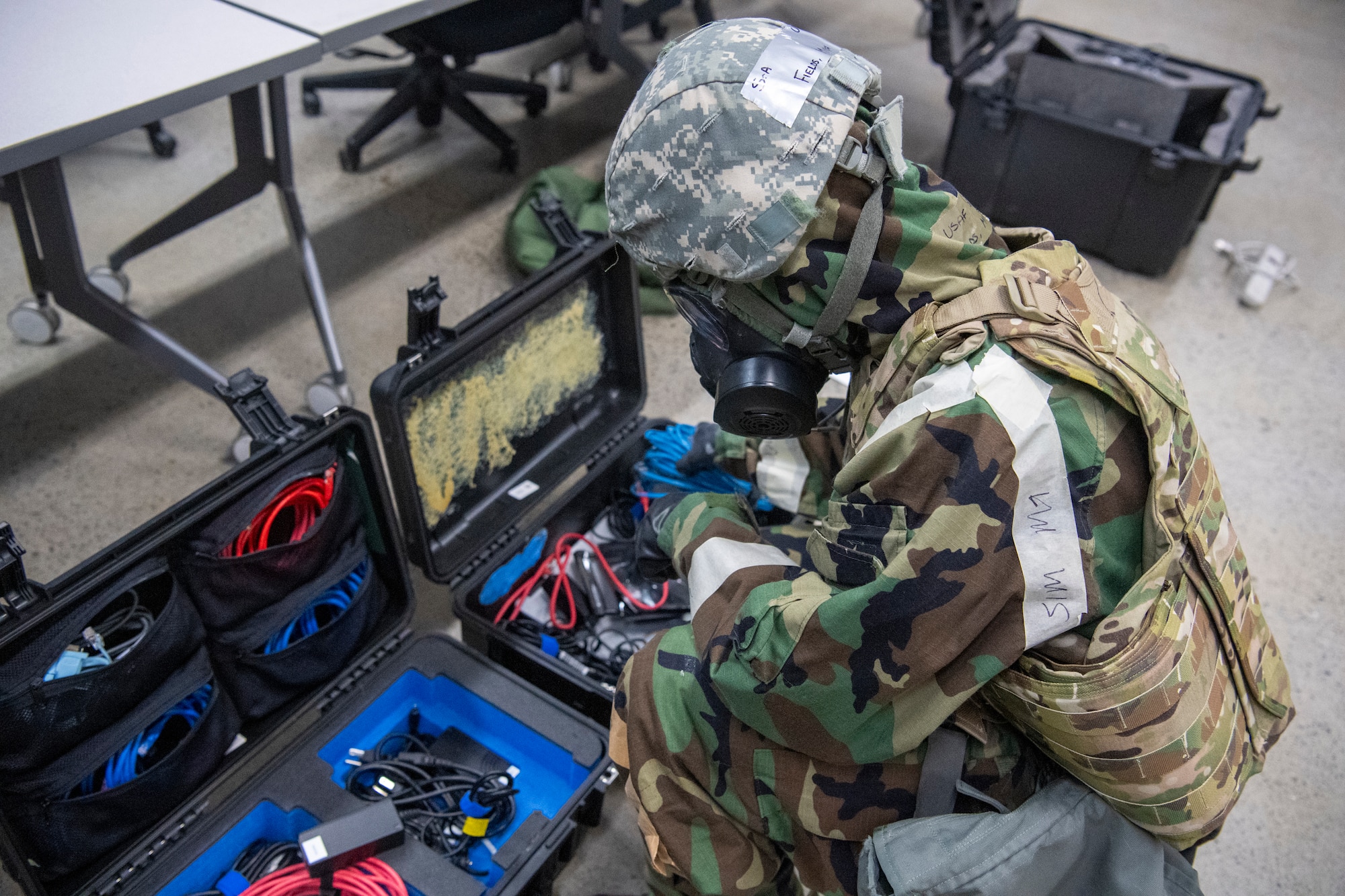 An airman grabs equipment part of a communication fly-away kit.