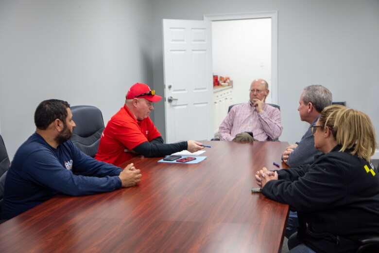 A group of employees sitting at a table having a meeting.