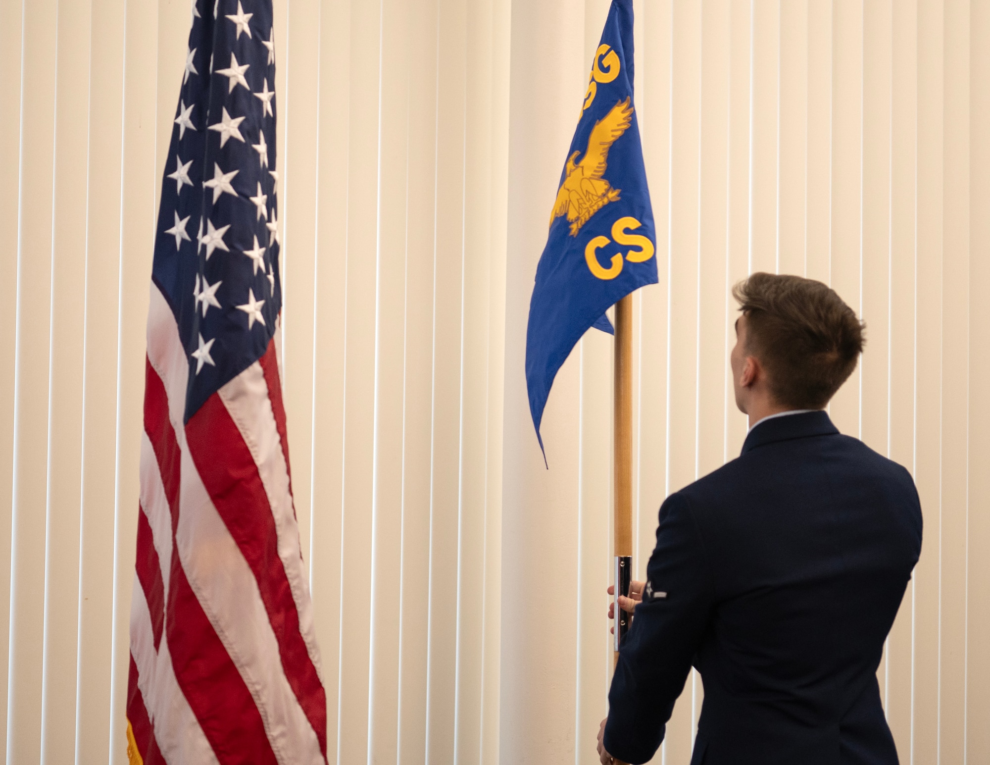 U.S. Air Force Airman Liam Bouman, 133rd Communication Squadron, places the new guidon in the stand in St. Paul, Minn., Feb. 1, 2025.