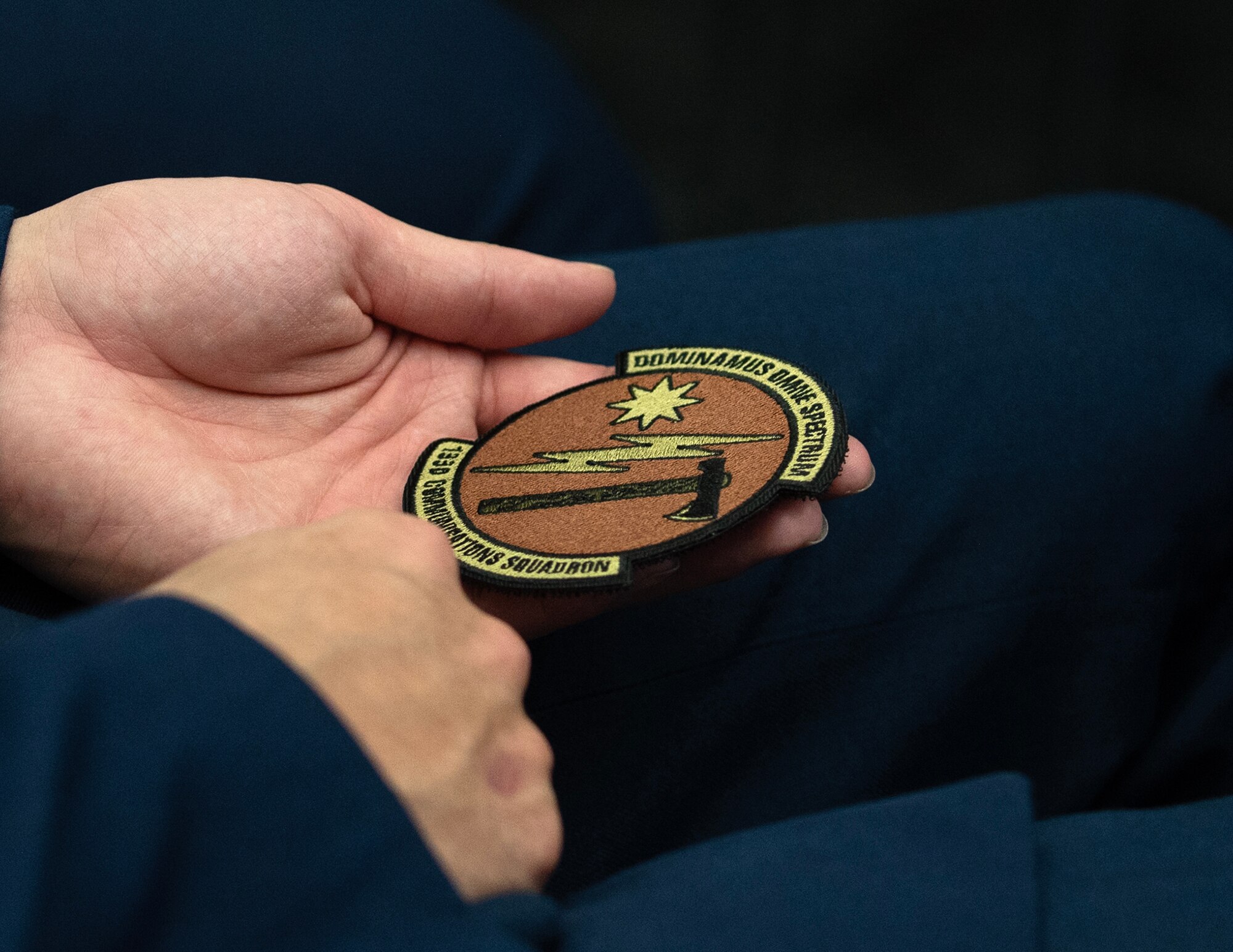 U.S. Air Force Airman, 133rd Communication Squadron, holds the new squadron patch in St. Paul, Minn., Feb. 1, 2025.