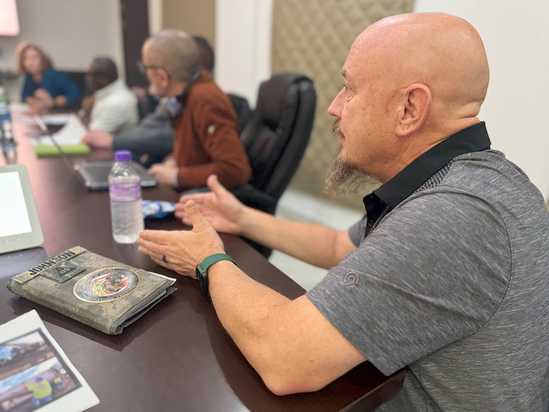 Bryton Johnson, U.S. Army Corps of Engineers Expeditionary District Deputy Engineer, discusses project details with Project Review Board attendees during District Governance Week at the district's Engineering Center of Excellence building in Kuwait, on January 14, 2025.