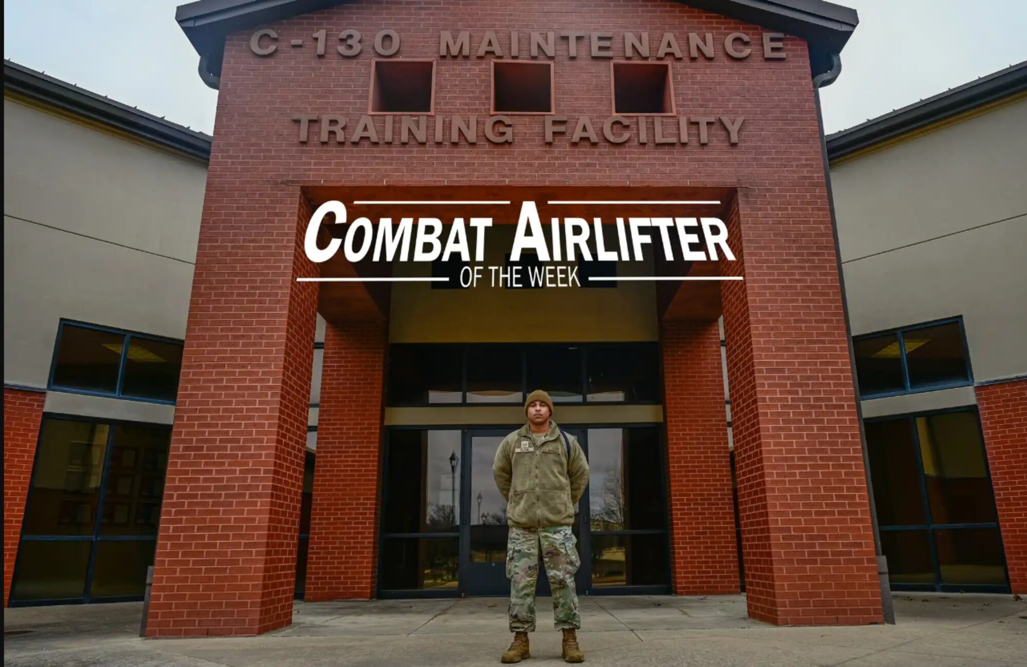 Man poses in front of building.