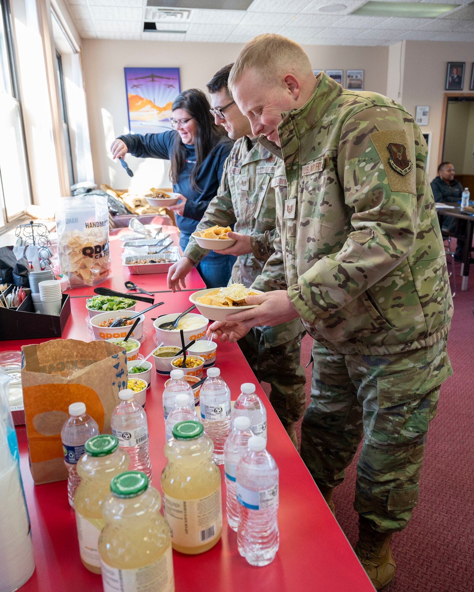 True North Airmen and civilians collect food during True North - Minot Installation Cohesion Meeting 2025 at the Northern Lights Chapel on Minot Air Force Base, North Dakota, Feb. 12, 2025. The meeting served as a moment for True North members to enjoy each other’s company and promote mental health and belonging. (U.S. Air Force photo by Senior Airman Kendra A. Ransum)