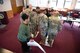 True North members participate in a team building exercise during the True North - Minot Installation Cohesion Meeting 2025 at the Northern Lights Chapel on Minot Air Force Base, North Dakota, Feb. 12, 2025. The team building activity, which involved participants fitting all their feet within gradually decreasing paper squares, demonstrated the importance of communication and adaptability. (U.S. Air Force photo by Senior Airman Kendra A. Ransum)