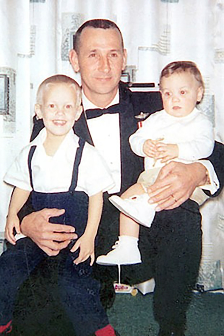 A man holds a child on both knees.