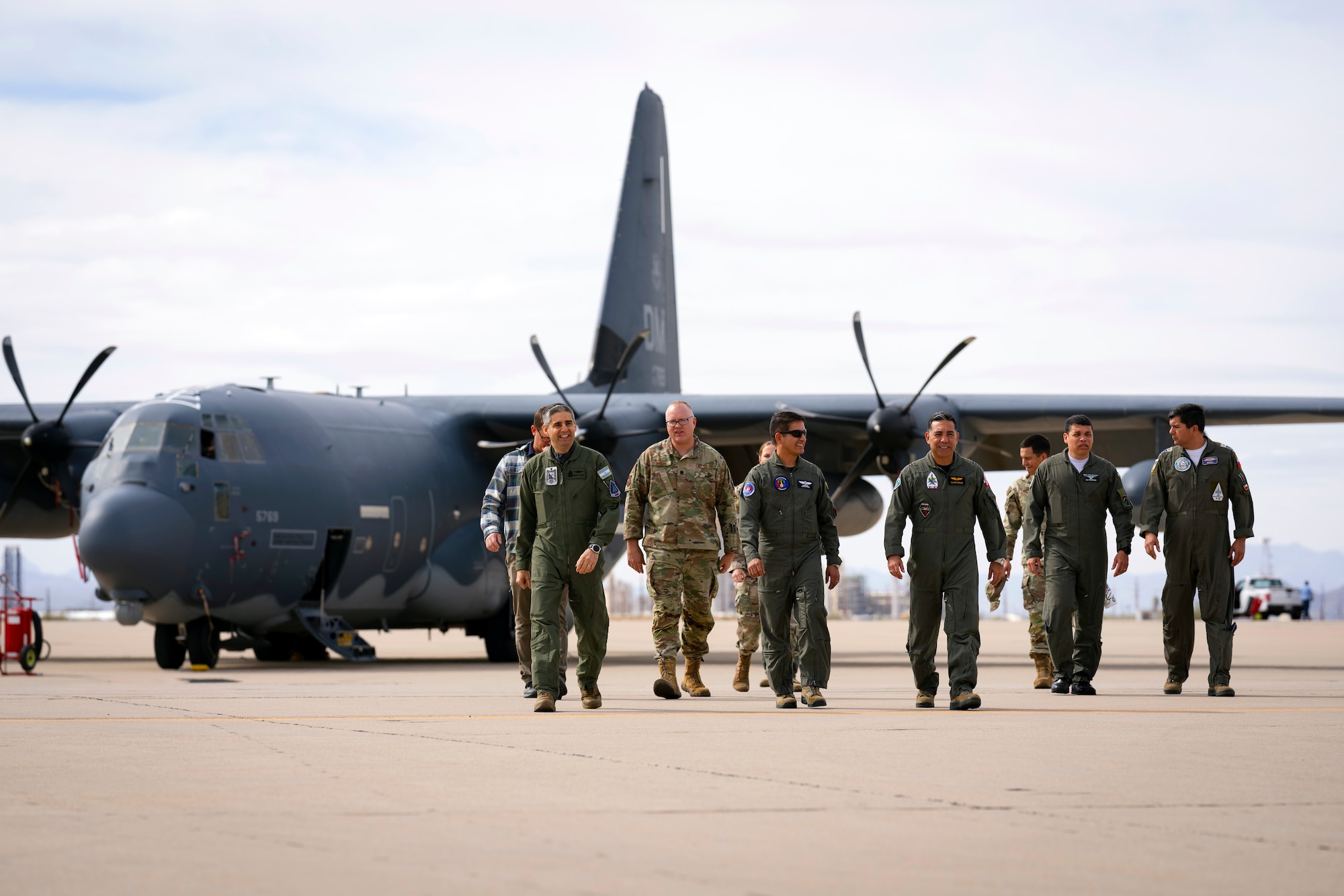 Air Forces Southern Foreign Liaison Officers and personnel walk the flightline after touring a HC-130J Combat King II assigned to the 355th Wing, Feb. 13, 2025 at Davis-Monthan Air Force Base, Arizona. The hands-on immersion provided valuable background and broadened perspectives on U.S. Air Force capabilities, reinforcing the U.S. military’s ongoing commitment to fostering international cooperation and ensuring security and stability in the U.S. Southern Command region. (U.S. Air Force Photo by Tech. Sgt. Rachel Maxwell)