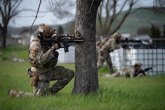 Man takes cover behind tree