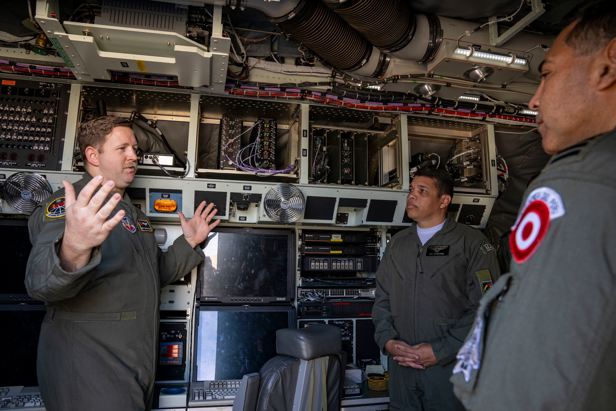 U.S. Air Force Tech. Sgt. Richard Westra, special equipment operator assigned to the 21st Surveillance Squadron, Det. 1, left, briefs Air Forces Southern Foreign Liaison Officers during a WC-135 Constant Phoenix tour, Feb. 13, 2025 at Davis-Monthan AFB, Arizona. The tour helped to provide a firsthand look about the aircraft’s capabilities and its role in nuclear treaty monitoring, reinforcing transparency and collaboration in countering threats. (U.S. Air Force Photo by Andrea Jenkins)