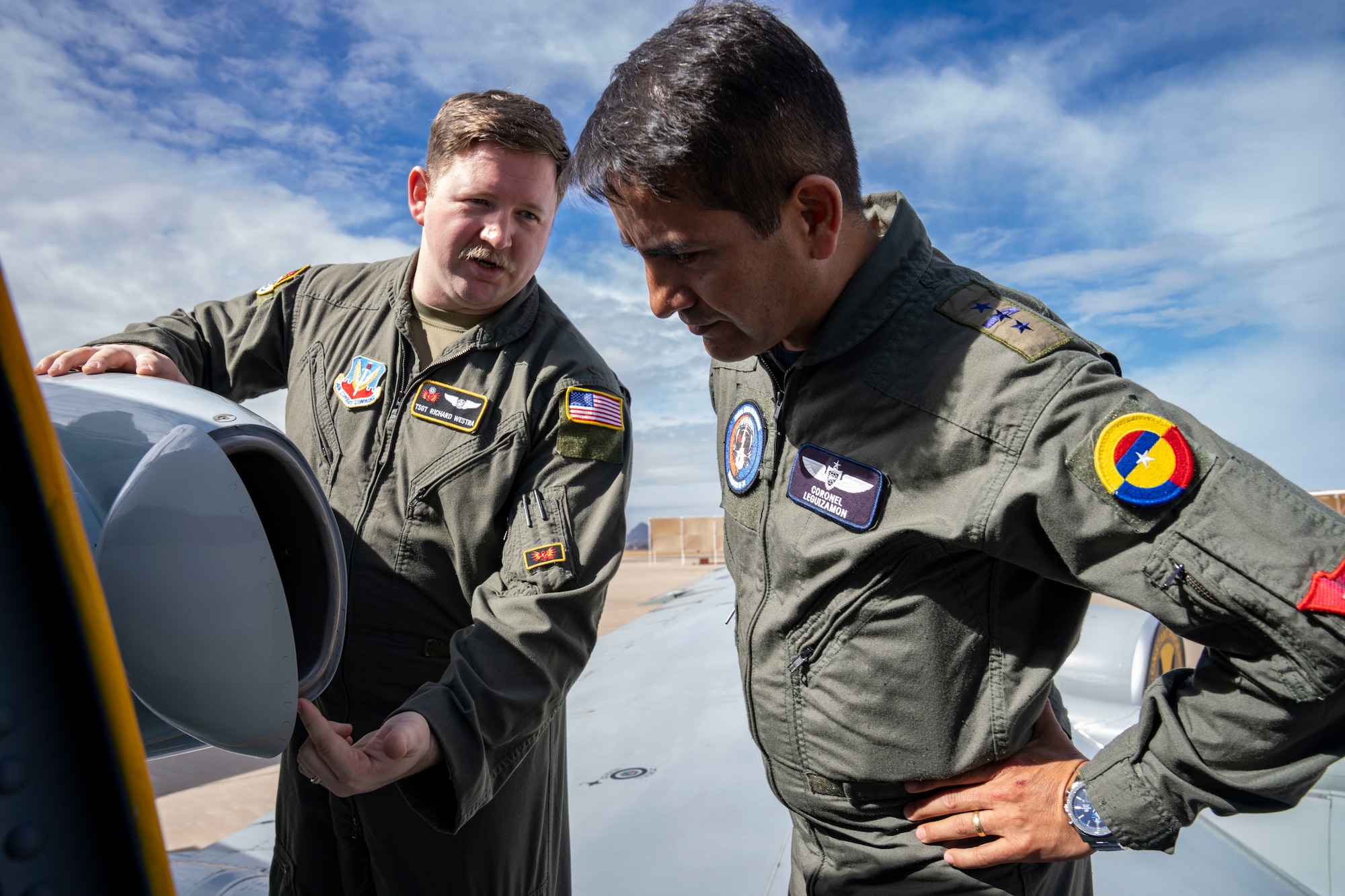 U.S. Air Force Tech. Sgt. Richard Westra, special equipment operator assigned to the 21st Surveillance Squadron, Det. 1, left, shows Colombian Air Force Col. Alejandro Leguizamón, right, Air Forces Southern Foreign Liaison Officer, how atmospheric particles are collected during a WC-135 Constant Phoenix tour, Feb. 13, 2025 at Davis-Monthan AFB, Arizona. The WC-135, which traveled from Offutt AFB, Nebraska, plays a critical role in nuclear treaty monitoring by collecting airborne effluents and particulates. (U.S. Air Force Photo by Andrea Jenkins)