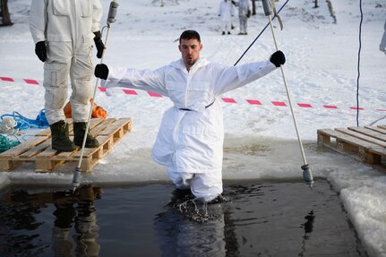 U.S. Army Capt. Chadwick Haider of the Minnesota National Guard steps into an icy lake during a field training exercise near Haltdalen, Norway, Feb. 12, 2025. The training was part of NOREX, the Reciprocal Norwegian Exchange, a partnership program whereby Minnesota Guardsmen and Norwegian Home Guardsmen visit the opposite country to train and exchange cultural understandings.