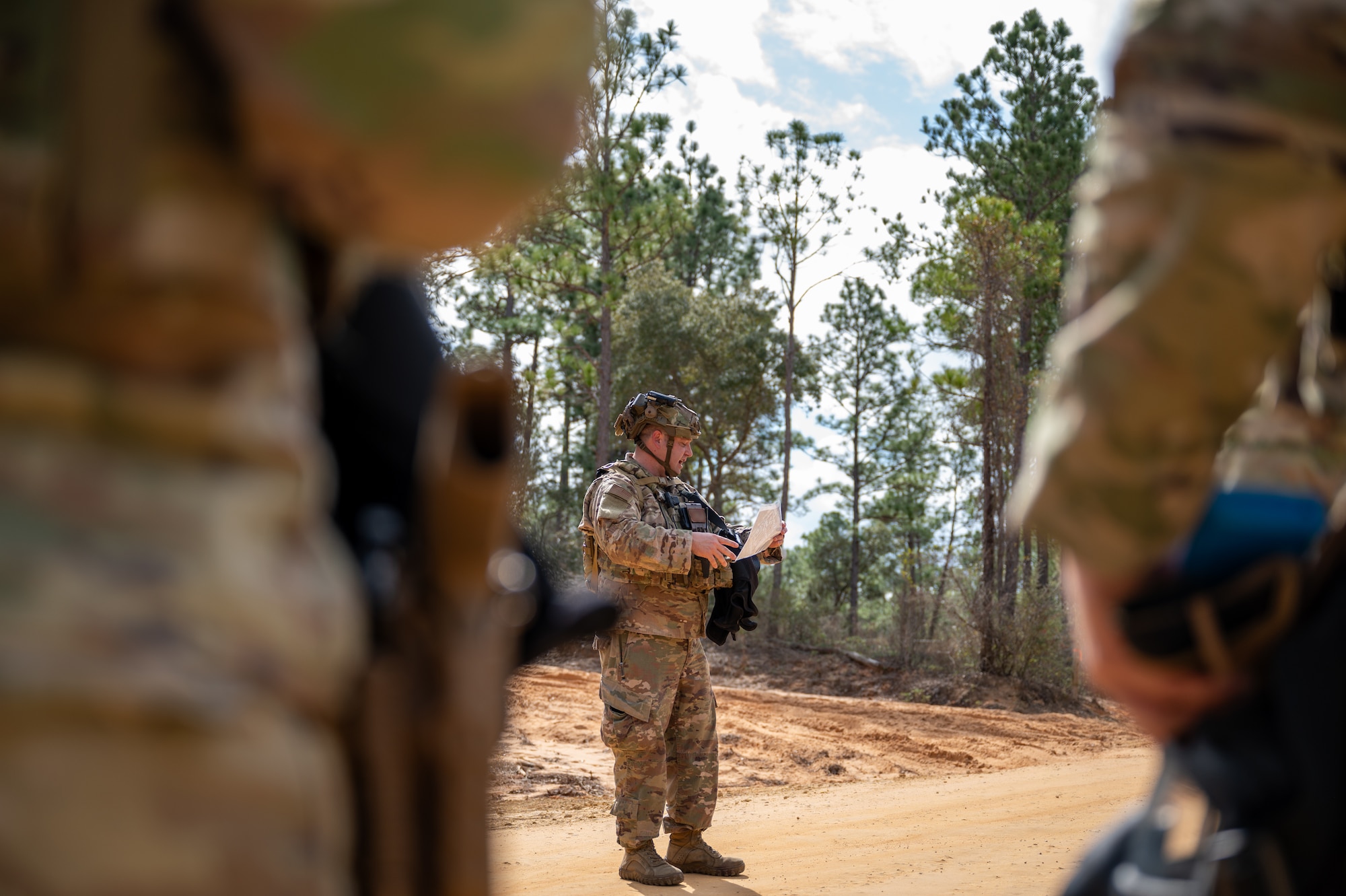 An Airman stands in front of a unit briefing them on the field training exercise they are about to begin.