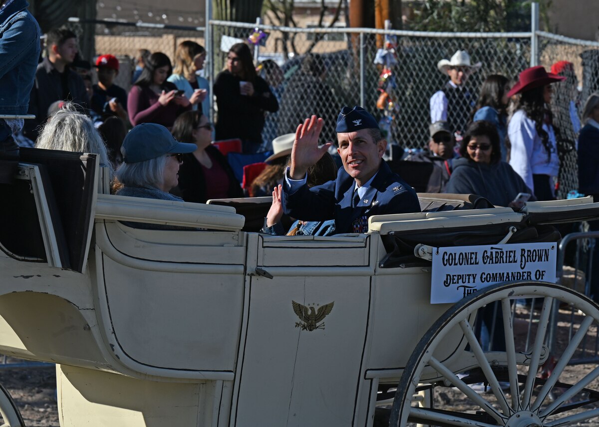 U.S. Air Force Col. Gabriel Brown, 355th Wing deputy commander, waves at the 100th Annual Tucson Rodeo Parade in Tucson, Arizona, Feb. 20, 2025. Brown’s attendance shows the commitment of Davis-Monthan Air Force Base to the local community. (U.S. Air Force photo by Staff Sgt. Abbey Rieves)