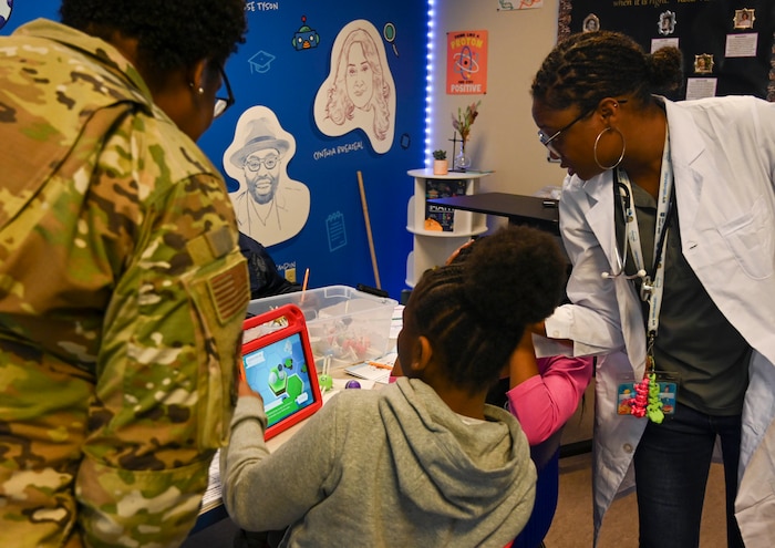 Students interact with a teacher and a service member