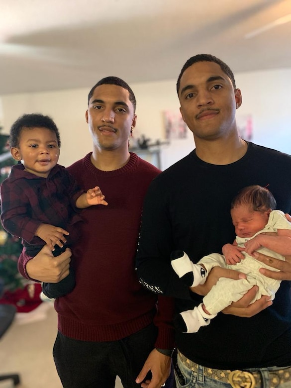 Twin brothers Jacob and Jacoi pose together with their children