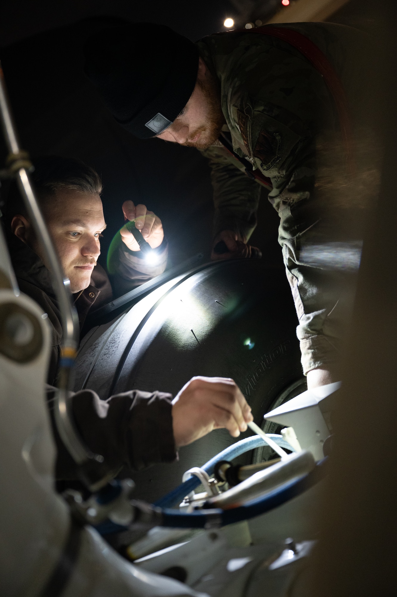 Senior Airman Cole Colclasure, right, and Senior Airman Craig Moccia, 55th Maintenance Squadron crew chiefs, remove a bolt to reset a linear actuator on a RC-135V/W Rivet Joint landing gear during Red Flag 25-1 at Nellis Air Force Base, Nevada Jan. 29, 2025.